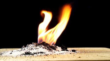 Experiment using Potassium permanganate KMnO4 and Sugar. Potassium permanganate and sugar can start a fire. Image on black background